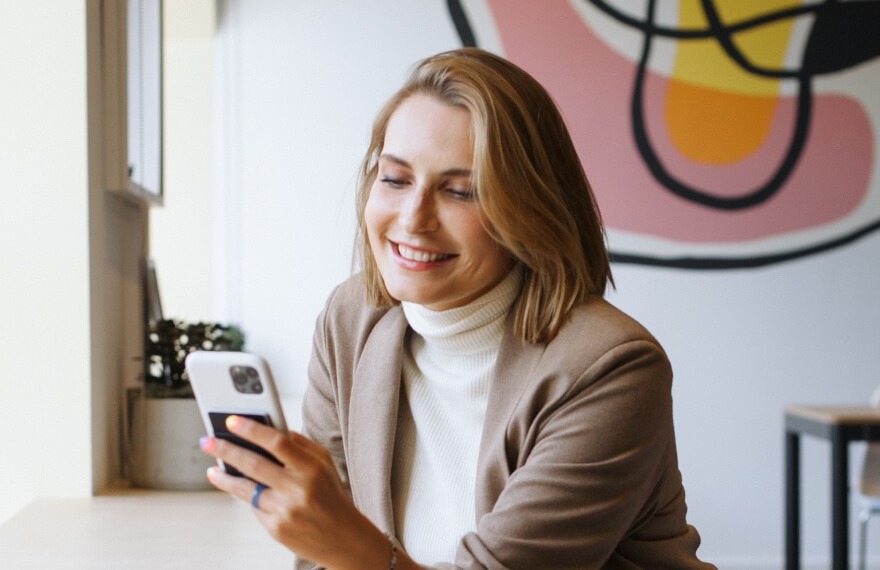 Woman smiling while she looks at her cellphone