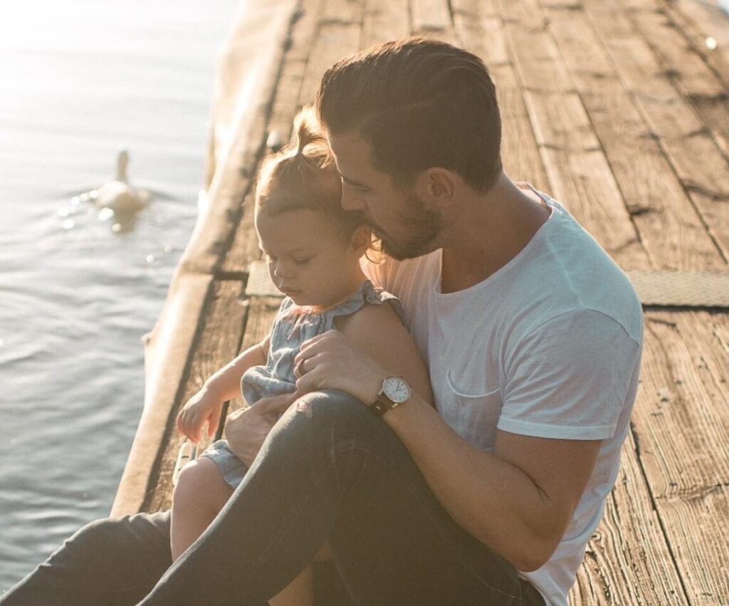 Father holding baby on a pier
