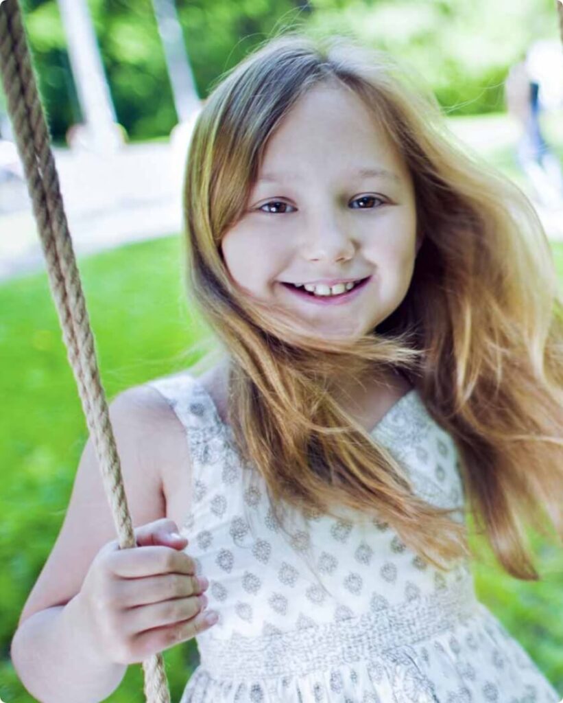 Young girl smiling on a swing
